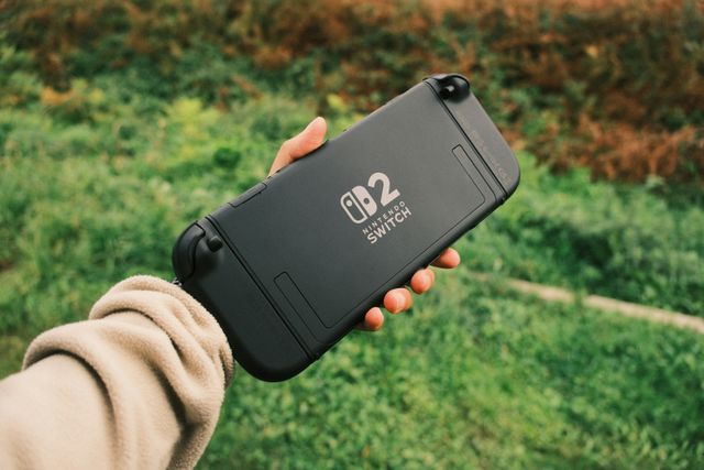 Person holding a Nintendo Switch in a natural outdoor setting, perfect for on-the-go gaming, https://www.pexels.com/photo/outdoor-handheld-gaming-with-nintendo-switch-34482311/src 